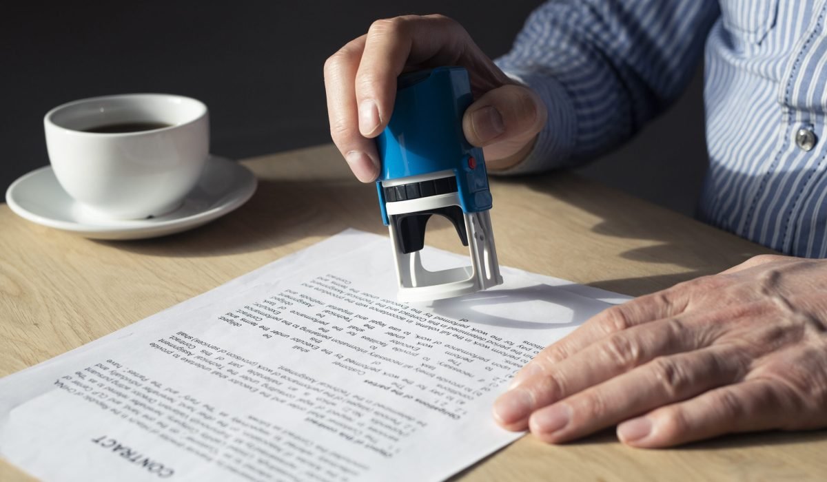 Businessman with mobile phone in hands and financial documents with numbers.