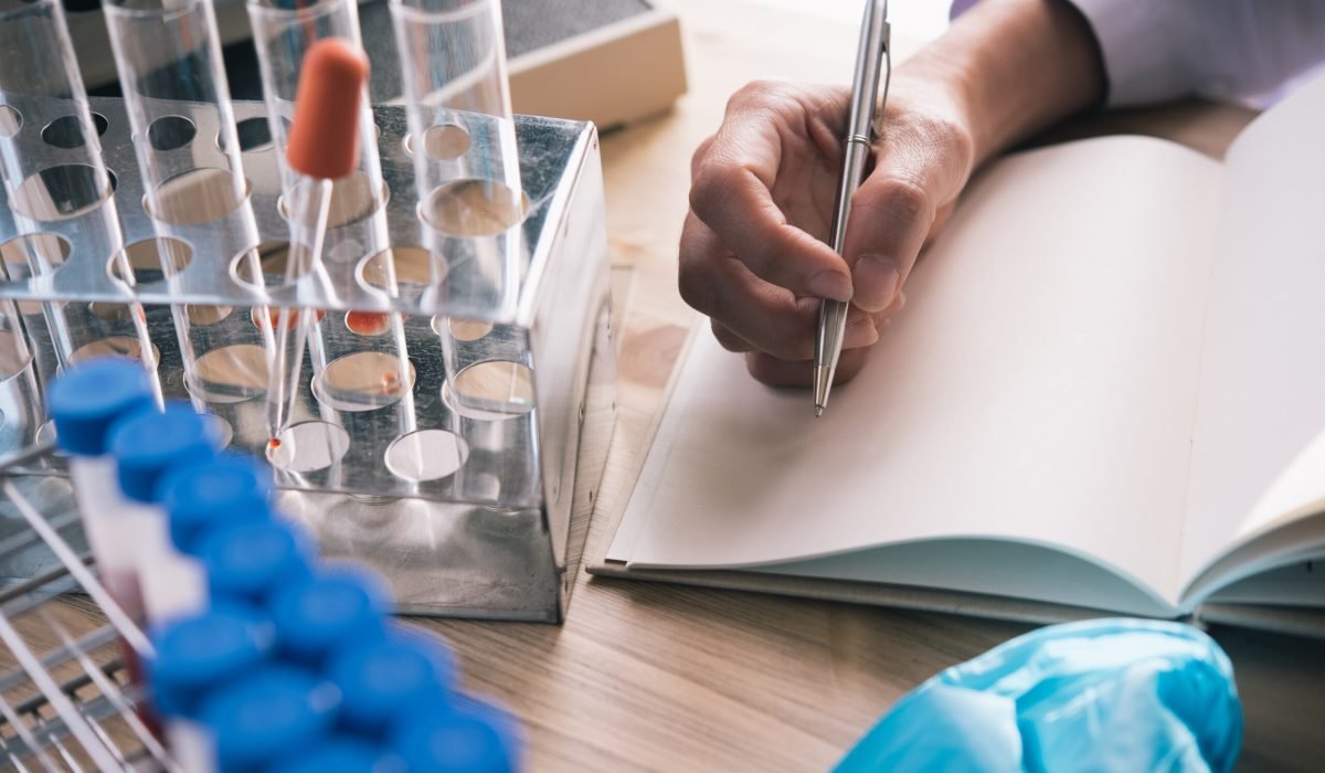 technician of health with blood tubes in the clinical lab for analytical ,she is Taking notes.