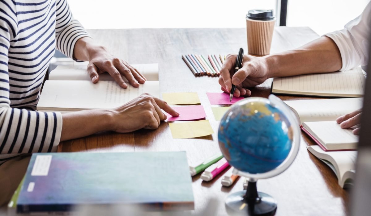 Tutor books with friends, Young students campus or classmates helps friend catching up workbook and learning tutoring in classroom practice preparing exam to entrance, Education school concept.